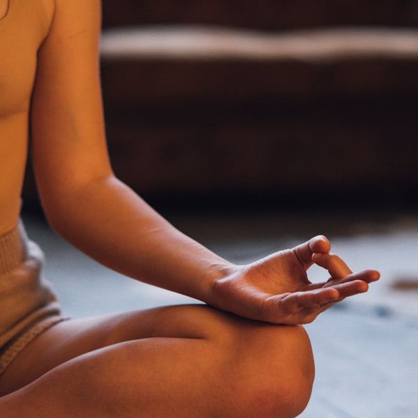 Person sitting in a cross-legged meditation pose, embodying balance.